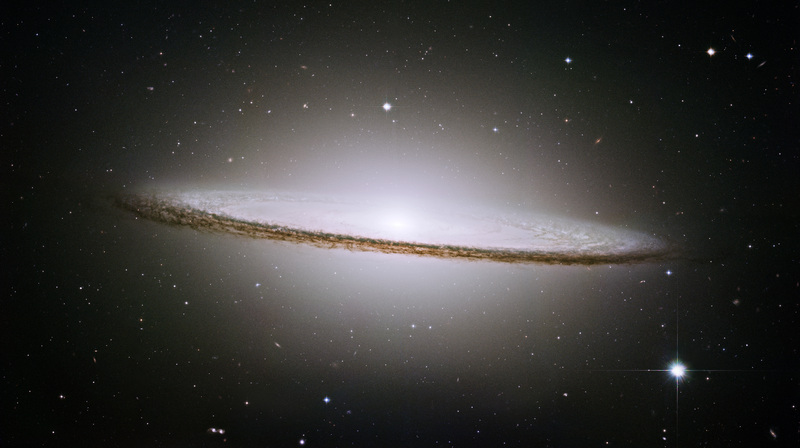 This image of the Sombrero Galaxy is a mosaic of six images taken by the Hubble Space Telescope's Advanced Camera for Surveys in May and June 2003 (exposition time: 10.2 hours).

The famous Sombrero galaxy (M104) is a bright nearby elliptical galaxy. The prominent dust lane and halo of stars and globular clusters give this galaxy its name. Something very energetic is going on in the Sombrero's center, as much X-ray light has been detected from it. This X-ray emission coupled with unusually high central stellar velocities cause many astronomers to speculate that a black hole lies at the Sombrero's center - a black hole a billion times the mass of our Sun.