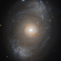 The brightly glowing bar portion of NGC 4151 as seen by Hubble. It is a Seyfert galaxy, which means that it has an actively accreting black hole at its nucleus, which presents itself to us as an intensely bright source. The two brighter portions near the top and bottom of the frame are where the bar terminates, and some fainter spiral arms extend outward from them.